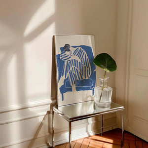 Kunstnerisk plakat med siddende figur i blå striber og bløde former på lys baggrund