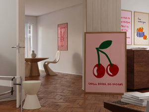 Feministisk plakat med røde kirsebær og teksten “Small Boobs, Big Dreams” i moderne, legende kunststil på lyserød baggrund