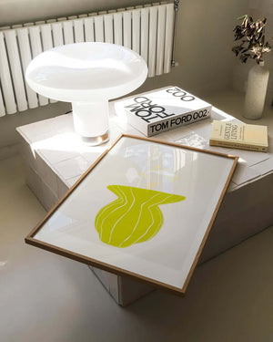 Plakat med grøn organisk form og fine linjer på lys baggrund i moderne indretning