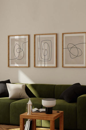 Moderne billedvæg med tre abstrakte line art plakater i beige og sort