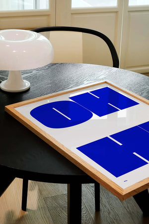 Grafisk typografi plakat i blå nuancer med geometriske bogstavformer på lys baggrund