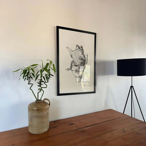 Humor plakat til badeværelset med illustration af en frø, der sidder på toilettet og læser avis i sort-hvid stil.