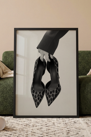 Sort hvid plakat med elegante stiletter holdt i hånden