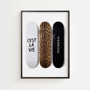 Moderne plakat med tre skateboards i hvid, leopardmønster og sort design.