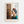Frida Kahlo plakat med profil foran rustik trævæg
