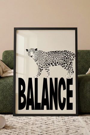 Balance leopard plakat med sort-hvid dyremotiv på store bogstaver i egetræsramme ved sofa