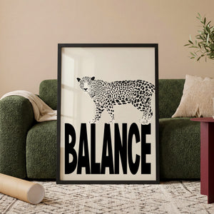 Balance leopard plakat med sort-hvid dyremotiv på store bogstaver i egetræsramme ved sofa