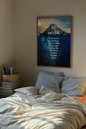 Success isbjerg plakat med fotografisk motiv og budskab i hvid typografi i egetræsramme over seng