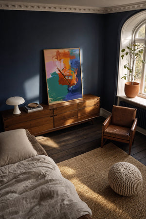 Dynamiske penselstrøg plakat i sort ramme over sofa i moderne stue