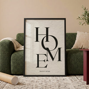 Hjem kært hjem typografiplakat i egetræsramme ved sofa