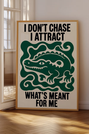 I Don't Chase I Attract plakat i egetræsramme på gulv ved vindue