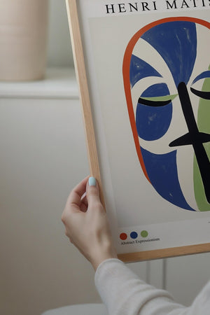 Plakat med farverigt stiliseret ansigt inspireret af Henri Matisse i blå og grønne former