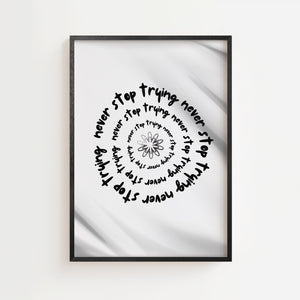 Never stop trying plakat med spiraltekst omkring blomsterform, sort ramme
