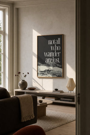 Not all who wander citatplakat i sort ramme over skrivebord på kontor