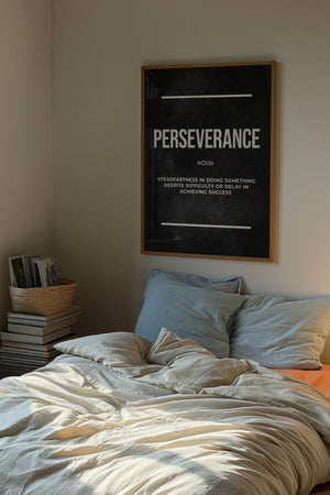 Perseverance definition plakat med hvid typografi på mørk baggrund i egetræsramme over seng