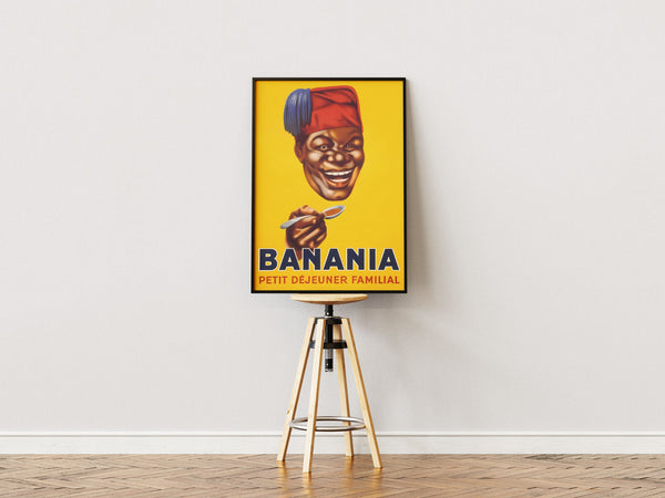 Vintage Banania plakat med smilende mand og ske – fransk retroreklame i gule og røde farver med teksten "Petit Déjeuner Familial".

