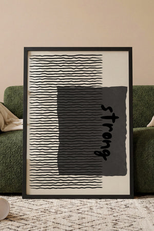 Strong stribet plakat med organisk typografi og grafiske linjer i sort-hvid i egetræsramme ved sofa
