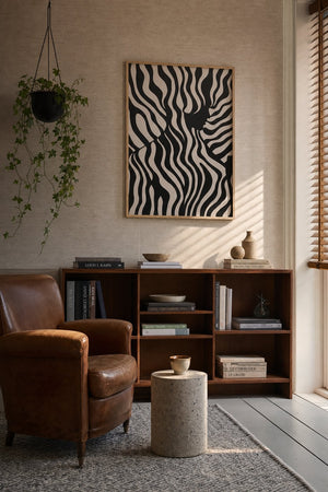 Zebrastriber plakat i sort ramme over sengebord i soveværelse